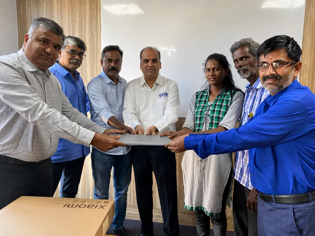 CDS hands over a laptop to a student supported by Sukrutha Trust.